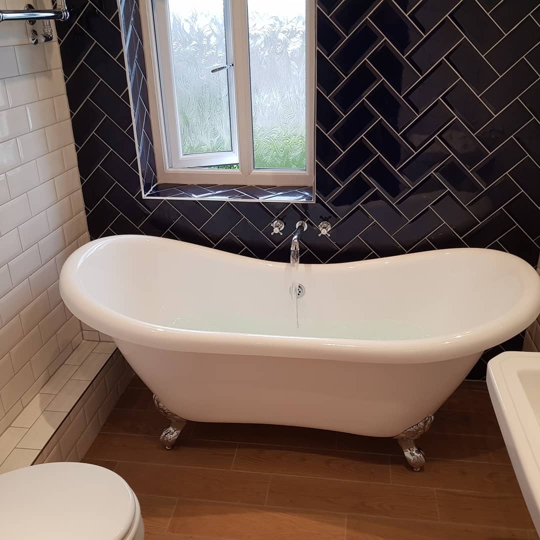 Clawfoot freestanding bath set against navy herringbone tile, fitted by DW Plumbing & Heating Yorkshire