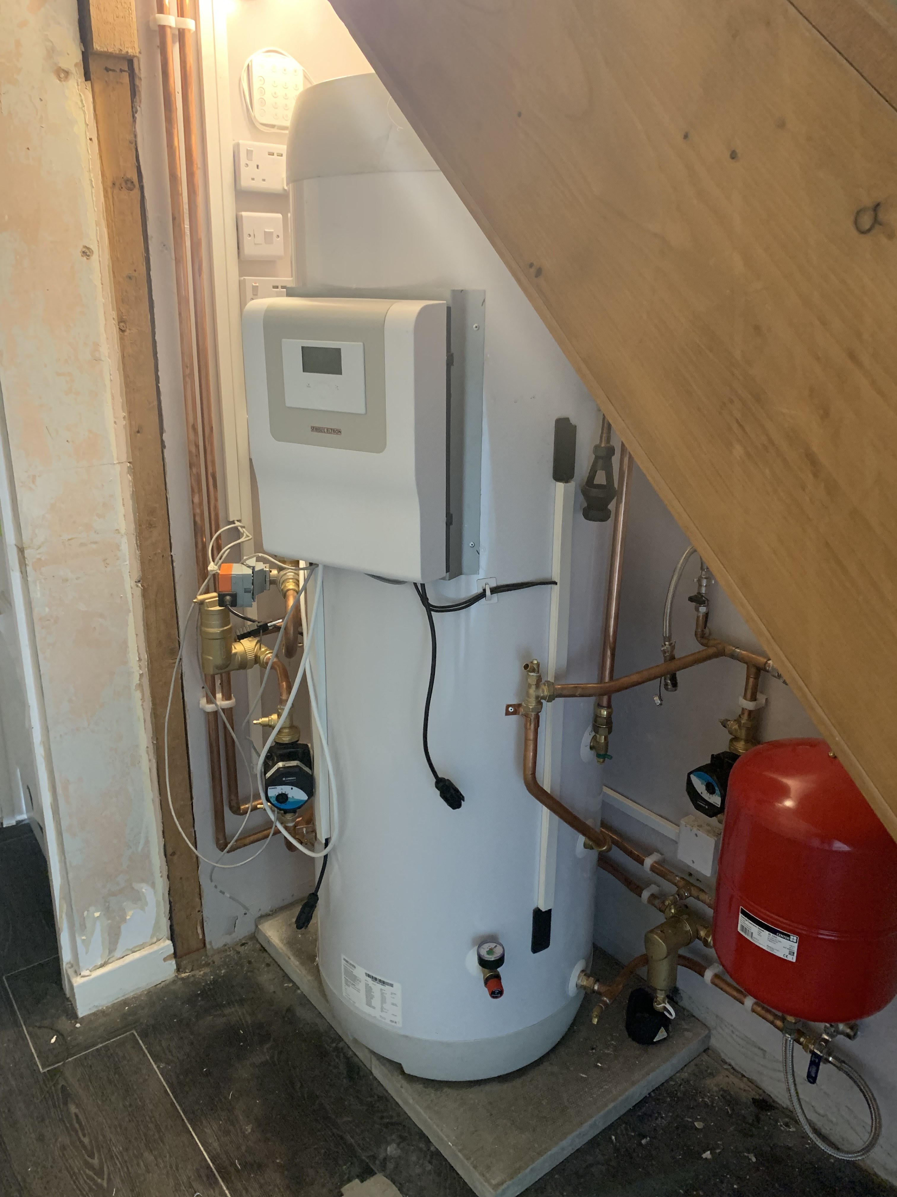 Air source heat pump indoor system installed by DW: unvented cylinder, Stiebel Eltron controls, pump set and expansion vessel under stairs