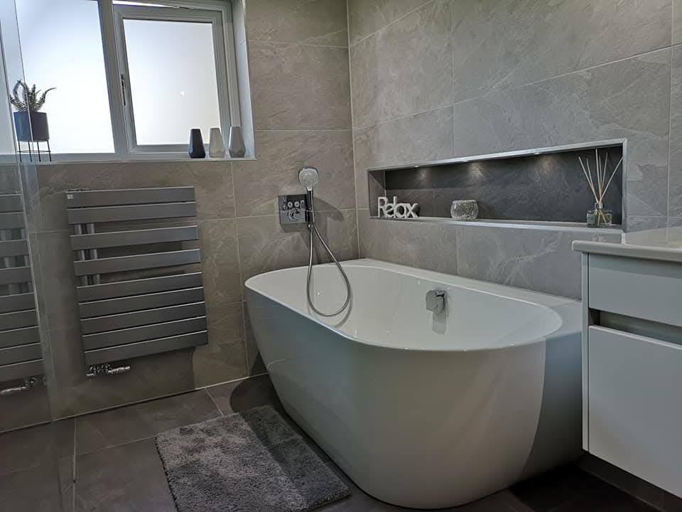 Master bathroom finished with freestanding bath, recessed niche and large-format slate-effect tile