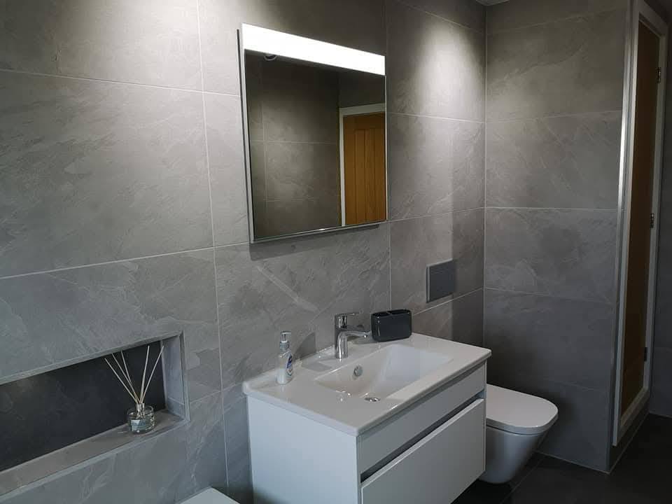 Vanity with backlit mirror and integrated basin in finished master bathroom