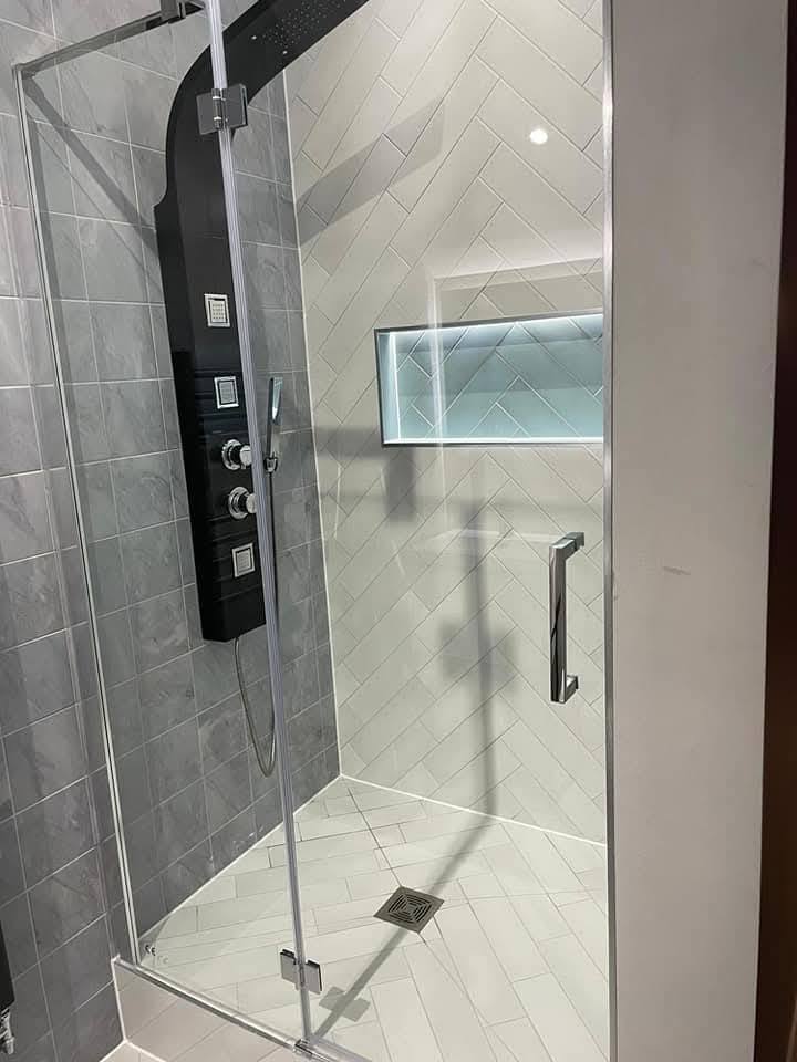 Compact shower room in the same property finished in white herringbone with black control panel